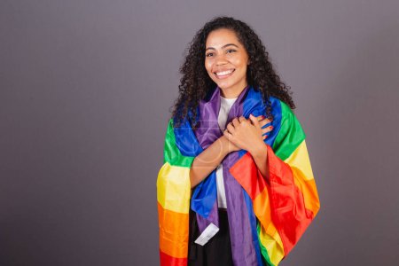 Téléchargez les photos : Jeune femme noire brésilienne, étreinte dans le drapeau LGBT, diversité, lutte contre les préjugés. - en image libre de droit