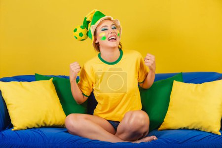 Photo for Caucasian Woman, Redhead, Brazil Soccer Supporter, Brazilian, On Couch Celebrating - Royalty Free Image