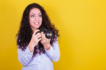 Téléchargez les photos : Femme caucasienne, photographe brésilienne, tenant un appareil photo, prenant des photos. Publicité, audiovisuel. - en image libre de droit