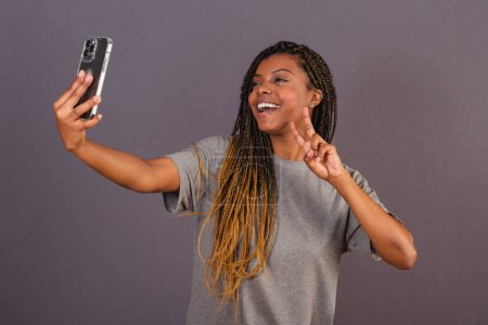 Foto de Joven mujer afro brasileña tomando autorretrato, selfie, foto, redes sociales. smartphone. - Imagen libre de derechos