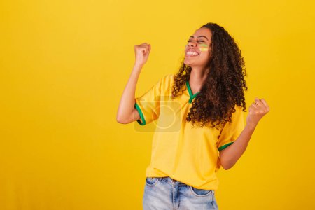 Foto de Joven brasileña negra, fanática del fútbol. celebrando y celebrando. - Imagen libre de derechos