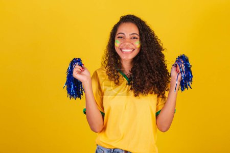 Photo for Young black Brazilian woman, soccer fan. holding cheerleader pom poms. - Royalty Free Image