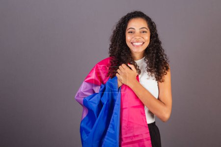 Photo for Young Brazilian black woman, bisexual flag on her chest singing anthem for diversity, Bisexual, LGBT, LGBTQ woman - Royalty Free Image