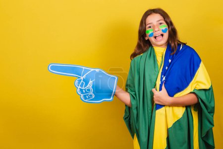 Photo for Brazilian caucasian child soccer fan pointing to the side, advertisement, promotion, advertisement. World Cup. Olympics. - Royalty Free Image