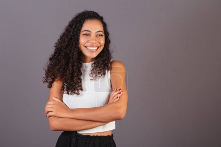 Photo for Young Brazilian black woman, with arms crossed, smiling. - Royalty Free Image
