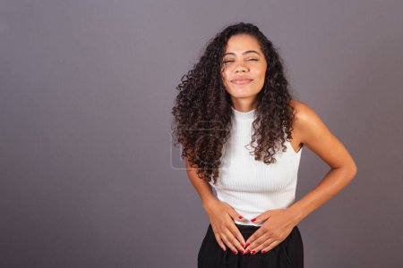Téléchargez les photos : Jeune femme noire brésilienne, avec crampes, douleurs abdominales. - en image libre de droit