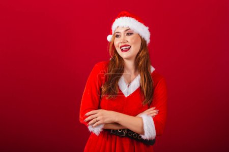 Photo for Beautiful Brazilian red-haired woman, dressed in Christmas clothes, Santa Claus. crossed arms. - Royalty Free Image