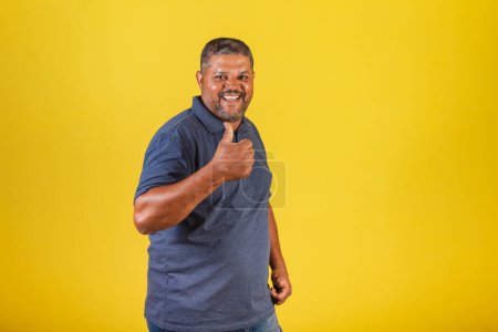 Téléchargez les photos : Homme noir brésilien, adulte souriant, genre. pouce levé, positif. - en image libre de droit