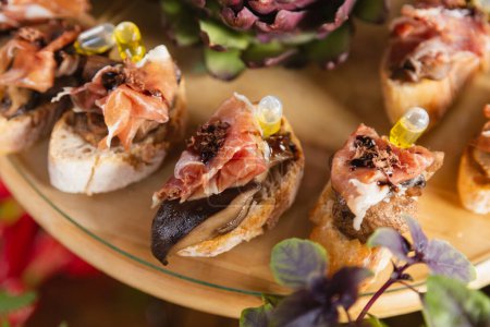 Foto de Comidas buffet gourmet. tostadas con lomo de jamón ahumado empapado en aceite de oliva. charcutería - Imagen libre de derechos