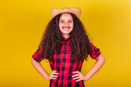 Photo for Caucasian girl, dressed as a boy, party clothes, hands on hips, happy and joyful. May, June and July festivities, festa junina celebrations - Royalty Free Image