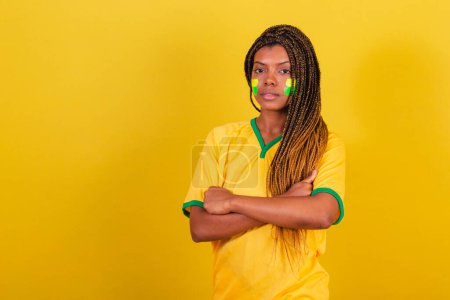 Téléchargez les photos : Femme noire jeune fan de football brésilien. oisif, sérieux, sérieux. - en image libre de droit