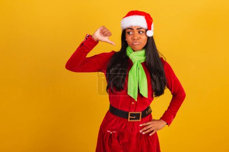 Téléchargez les photos : Belle femme brésilienne noire, vêtue de vêtements de Noël, Père Noël claus, n'aime pas signe, négatif. - en image libre de droit