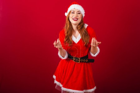 Téléchargez les photos : Belle femme rousse brésilienne, vêtue de vêtements de Noël, le Père Noël. invitant les mains. - en image libre de droit