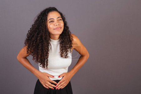Photo for Young Brazilian black woman, with cramps, abdominal pain. - Royalty Free Image