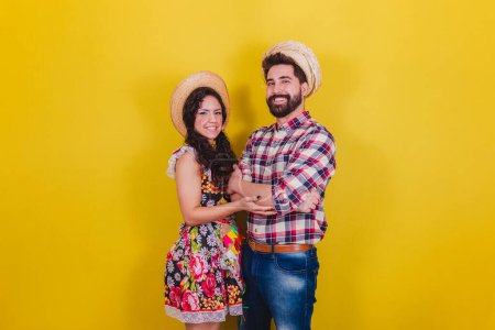 Téléchargez les photos : Beau couple vêtu de vêtements typiques pour une Festa Junina. Arraia de Sao Joao. avec bras croisés - en image libre de droit