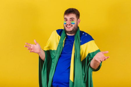 Photo for Caucasian brazilian man, soccer fan from brazil, with open arms in doubt. - Royalty Free Image