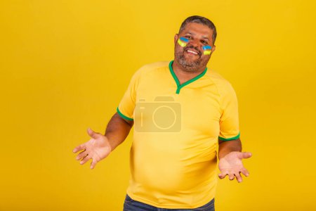 Foto de Hombre negro brasileño, fanático del fútbol de Brasil. con los brazos abiertos, bienvenidos. - Imagen libre de derechos