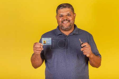 Foto de Hombre negro brasileño, adulto con licencia de conducir, documento brasileño y llave de auto. - Imagen libre de derechos