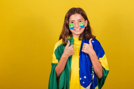 Photo for Brazilian, caucasian child, soccer fan, thumb up. approving, approval, affirmative. World Cup. Olympics. - Royalty Free Image