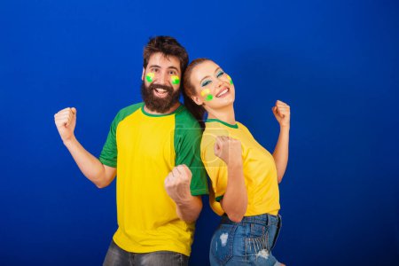 Photo for Caucasian couple, soccer fans from Brazil, celebrating team victory - Royalty Free Image
