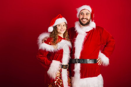 Foto de Pareja brasileña, vestida con ropa de Navidad, Santa Claus, sonriendo a la cámara - Imagen libre de derechos