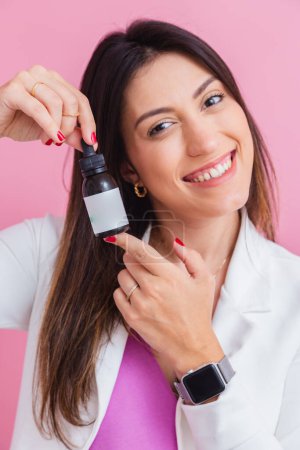 Photo for Medical beautician, with bottles of vitamin, supplementation. in a dropper bottle. - Royalty Free Image