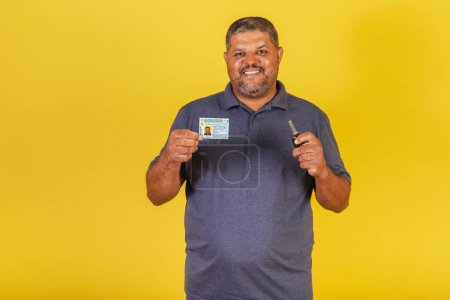 Foto de Hombre negro brasileño, adulto con licencia de conducir, documento brasileño y llave de auto. - Imagen libre de derechos