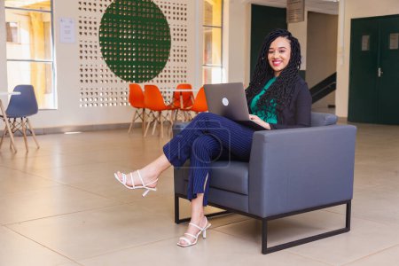 Photo for Young black woman, brazilian, entrepreneur, businesswoman, in armchair, with notebook - Royalty Free Image