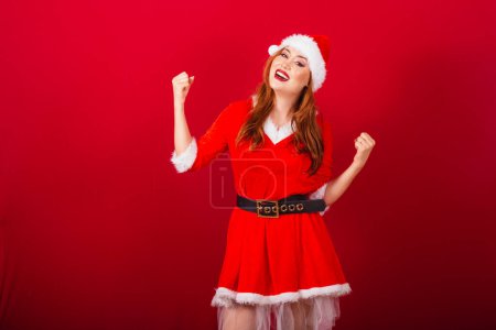 Téléchargez les photos : Belle femme rousse brésilienne, vêtue de vêtements de Noël, le Père Noël. célébrer. - en image libre de droit