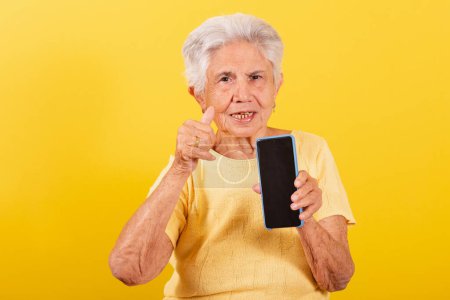 Téléchargez les photos : Vieille dame, téléphone portable, inclusion des personnes âgées dans l'environnement numérique, en ligne, smartphone. Pointant vers l'écran. - en image libre de droit