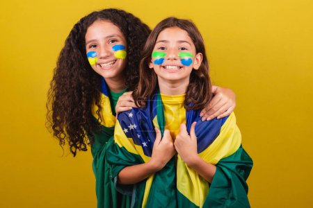 Téléchargez les photos : Sœurs et amis supporters du Brésil, fans de football, souriant à la caméra en regardant le match du Brésil. Coupe du Monde. Jeux olympiques. - en image libre de droit
