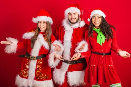 Téléchargez les photos : Amis brésiliens avec des vêtements de Noël, Santa Claus. À bras ouverts, bienvenue. - en image libre de droit