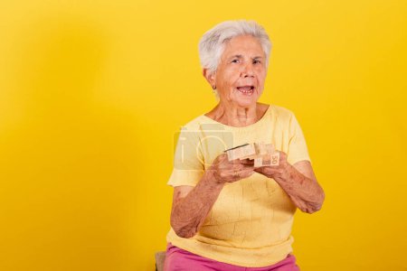 Photo for Old lady holding money banknotes, salary, retirement, economy and finance concept. - Royalty Free Image