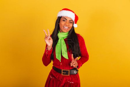 Photo for Beautiful black Brazilian woman, dressed in christmas clothes, santa claus, pose for selfie. peace and love. - Royalty Free Image