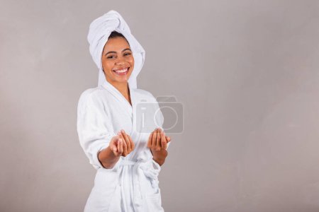 Téléchargez les photos : Belle femme noire brésilienne, portant peignoir et serviette. invitant, appelant avec les mains. - en image libre de droit