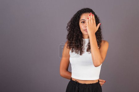Photo for Young Brazilian black woman, hand in front of her face, concept violence against women, feminicide. - Royalty Free Image