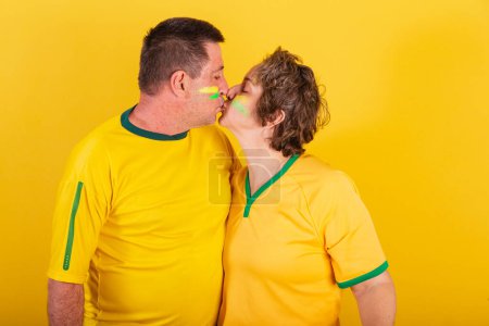 Photo for Adult couple, soccer fan from brazil, kissing. - Royalty Free Image