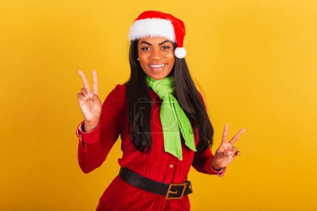 Photo for Beautiful black Brazilian woman, dressed in christmas clothes, santa claus, pose for selfie. peace and love. - Royalty Free Image