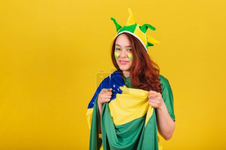 Photo for Caucasian woman, redhead, soccer fan from Brazil, pointing at camera, choosing you, suggestion, publicity photo. - Royalty Free Image