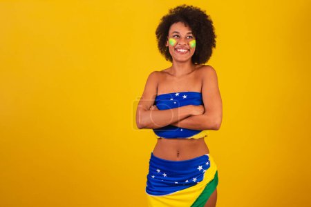Téléchargez les photos : Jeune femme noire fan de football brésilien. bras croisés - en image libre de droit