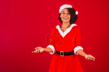 Photo for Beautiful black brazilian woman, dressed as santa claus, mama claus, with open arms, welcome - Royalty Free Image