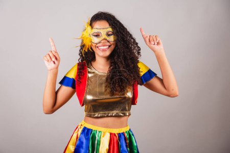 Téléchargez les photos : Belle femme brésilienne noire, avec des vêtements frevo, carnaval. Portant un masque, dansant sur la fanfare du carnaval. - en image libre de droit