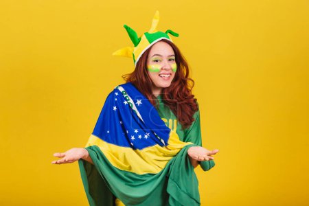 Photo for Caucasian woman, redhead, soccer fan from Brazil, with open arms, welcome. - Royalty Free Image