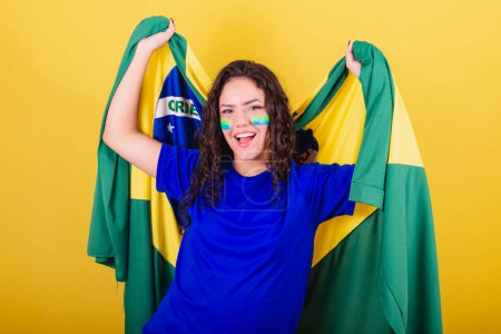 Photo for Woman soccer fan, fan of Brazil, world cup, dancing with flag on her back, celebrating victory. - Royalty Free Image