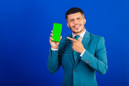 Foto de Hombre negro brasileño, vestido con traje y corbata azul. hombre de negocios. pantalla del teléfono inteligente y aplicación - Imagen libre de derechos