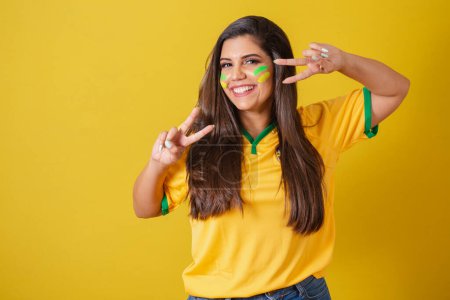 Photo for Woman supporter of Brazil, world cup 2022, football championship, With peace and love sign with fingers. - Royalty Free Image