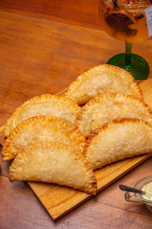fried pastry, fogazza, meat pastry, cheese pastry, served with mayonnaise and chili sauce, timico Brazilian bar snack. Served gin and tonic drink.