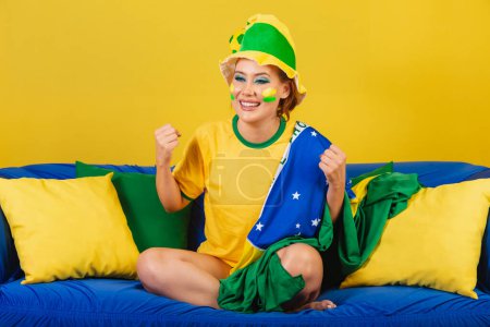 Photo for Caucasian woman, redhead, Brazilian soccer fan, Brazilian, celebrating, cheering victory - Royalty Free Image