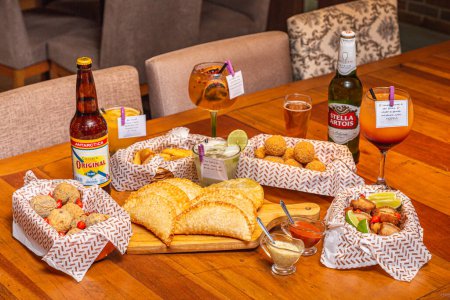 Foto de Varios aperitivos brasileños, servidos con cervezas famosas y bebidas típicas, juego de mesa - Imagen libre de derechos