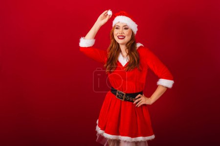 Téléchargez les photos : Belle femme rousse brésilienne, vêtue de vêtements de Noël, le Père Noël. posant pour la photo. - en image libre de droit